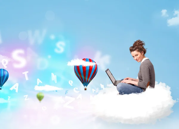 Young woman sitting in cloud with laptop — Stock Photo, Image