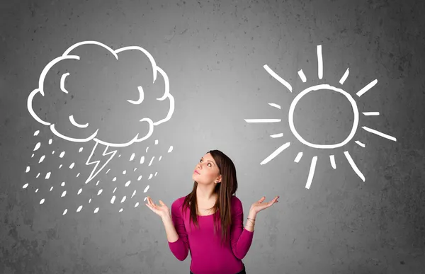 Woman standing between a sun and a rain drawing — Stock Photo, Image