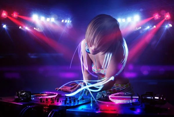 Disco jockey chica jugando música con efectos de haz de luz en el escenario —  Fotos de Stock