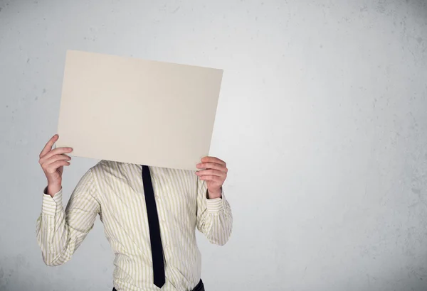 Biznesmen trzymający przed głową papier z przestrzenią do kopiowania — Zdjęcie stockowe