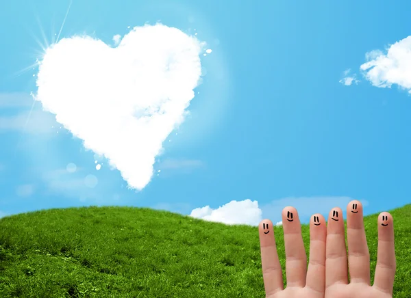 Happy smiley fingers looking at heart shaped cloud — Stock Photo, Image