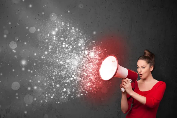 Женщина кричит в мегафон и исследует светящиеся частицы энергии — стоковое фото