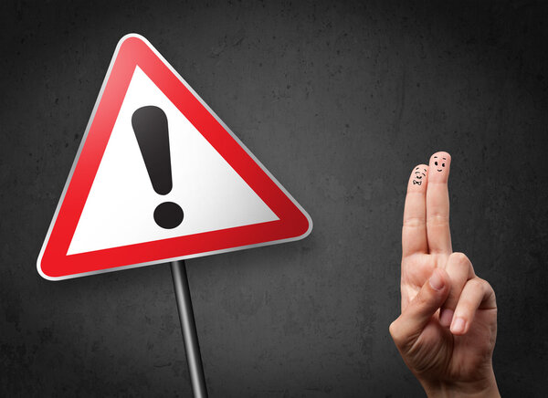 Счастливые улыбающиеся пальцы глядя на треугольник предупреждающий знак с excla
