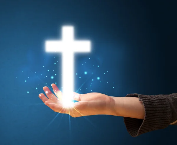 Glowing cross in the hand of a woman — Stock Photo, Image