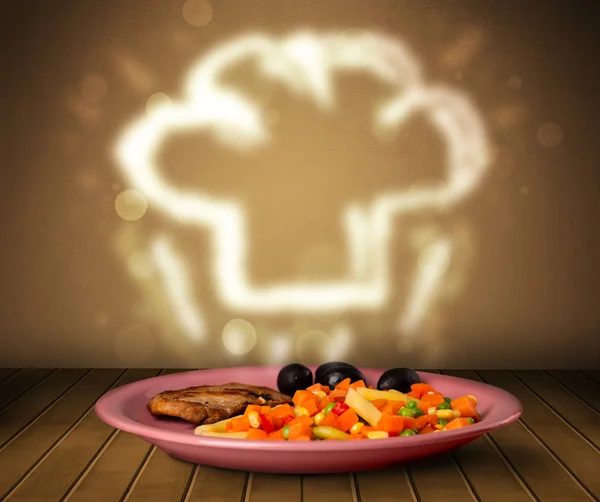 Heerlijk eten bord met chef-kok hoed — Stockfoto