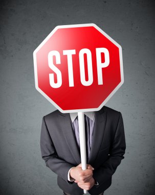 İşadamı elinde dur levhası tutuyor.