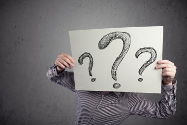 onun önünde soru işareti olan bir kağıt tutan işadamı 