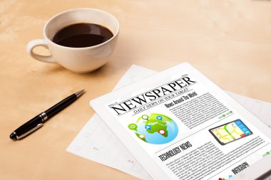Tablet bilgisayarı haberleri ekranda bir fincan kahveyle sunar.