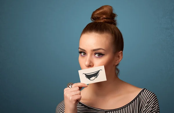 Feliz bonito menina segurando papel com engraçado smiley desenho — Fotografia de Stock