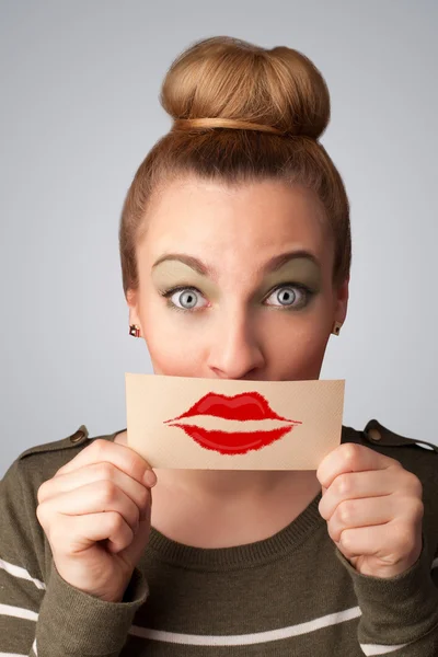 Happy pretty woman holding card with kiss lipstick mark — Stock Photo, Image