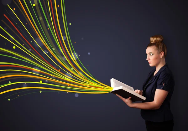 Pretty young woman reading a book while colorful lines are comin — Stock Photo, Image