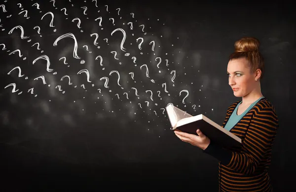 Pretty woman reading a book with question marks coming out from — Stock Photo, Image