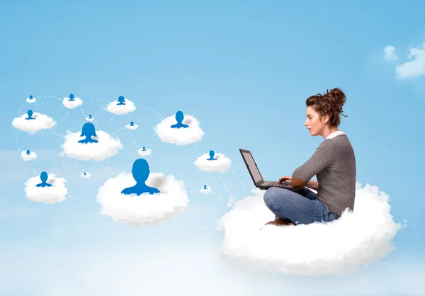 Young woman sitting in cloud with laptop — Stock Photo, Image