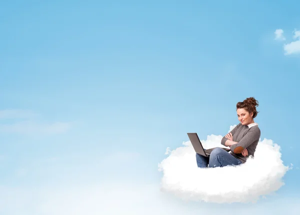 Young woman with laptop sitting on cloud with copy space — Stock Photo, Image