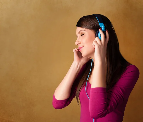Jeune femme avec écouteurs écoutant de la musique avec espace de copie — Photo