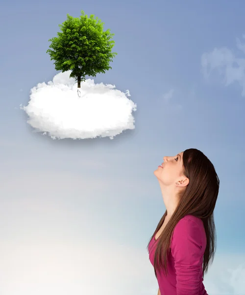 Jong meisje wijzend op een groene boom op de top van een witte wolk — Stockfoto