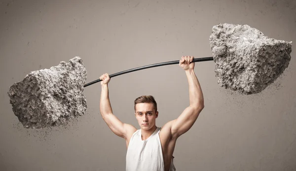 Musclé homme soulevant de grands poids de pierre de roche — Photo