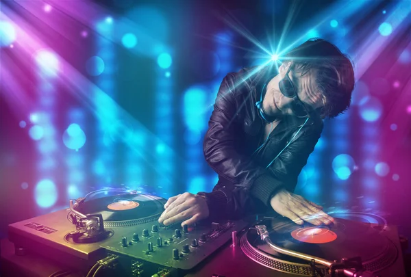 DJ mixen van muziek in een club met blauw en paars lichten — Stockfoto