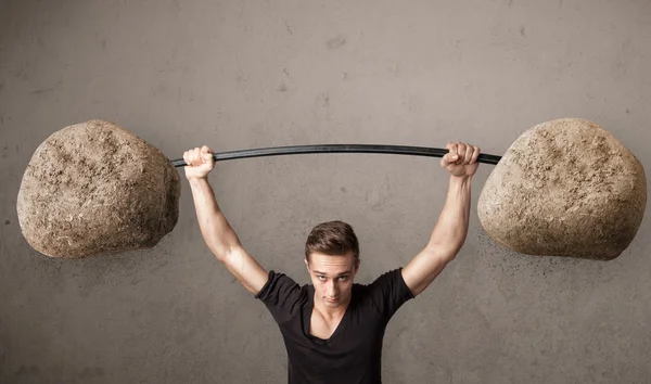 Muscular man lifting large rock stone weights — Stock Photo, Image