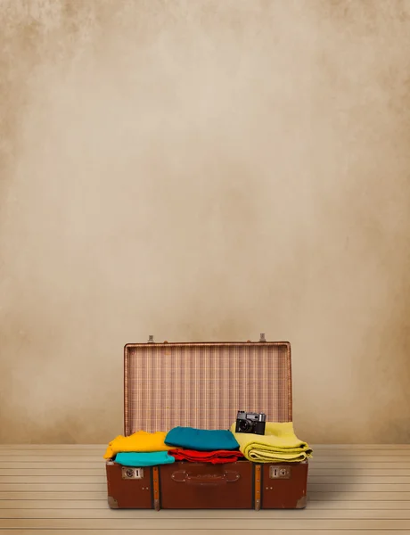 Retro tourist luggage with colorful clothes and copyspace — Stock Photo, Image