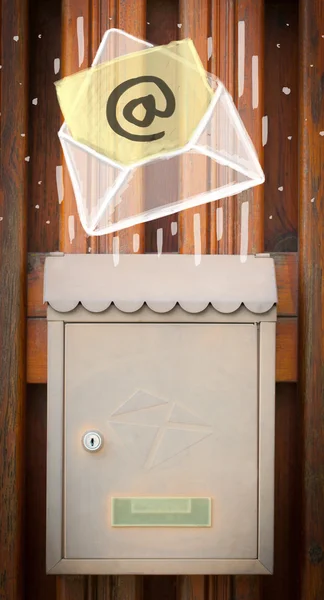 Envelope with email sign dropping into mailbox — Stock Photo, Image