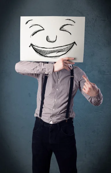 Бизнесмен держит газету с улыбающимся лицом перед носом — стоковое фото