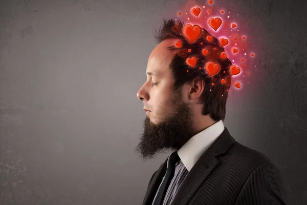 Ung människa tänker på kärlek med röda hjärtan — Stockfoto