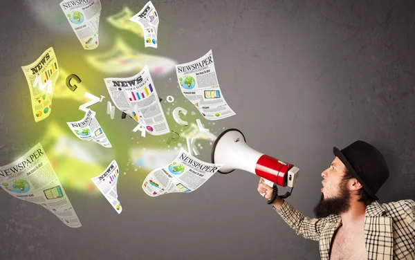 Guy yelling into loudspeaker and newspapers fly out — Stock Photo, Image