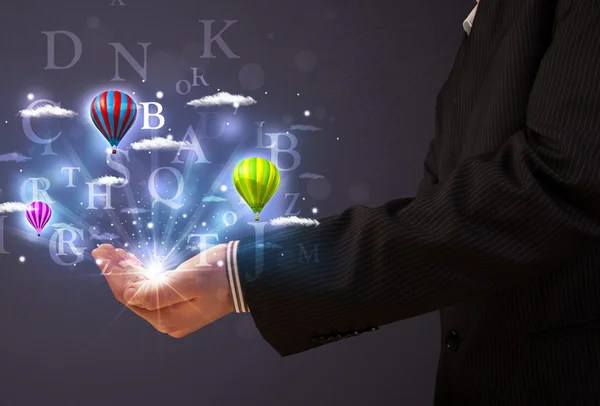 Letters and balloons in the hand of a businessman — Stock Photo, Image