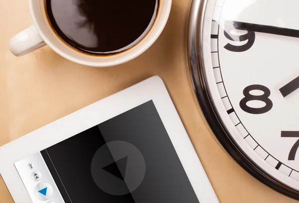 Tablet pc showing media player on screen with a cup of coffee on — Stock Photo, Image