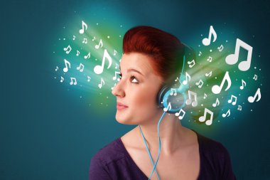 Kulaklıklı genç bir kadın müzik dinliyor.
