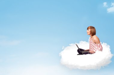 laptop kopya alanı ile bulut üzerinde oturan genç kadın