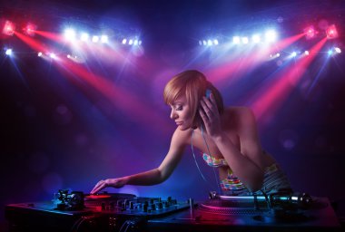 Genç dj kayıtları bir kalabalığın önünde sahnede karıştırma