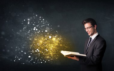 Genç adam sihirli bir kitap okuyor.