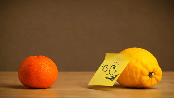 Limón con nota post-it mirando curiosamente a naranja — Foto de Stock