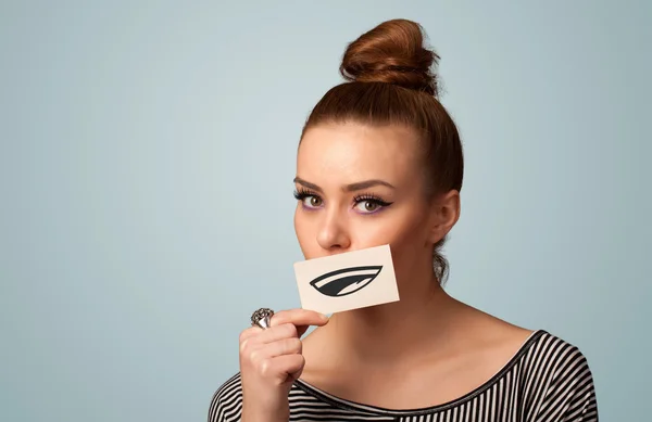 Pretty young girl holding white card with smile drawing — Stock Photo, Image