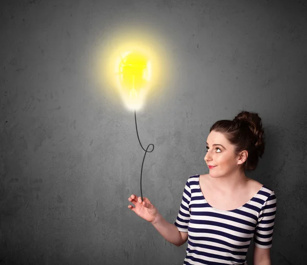 Woman holding a lightbulb balloon — Stock Photo, Image