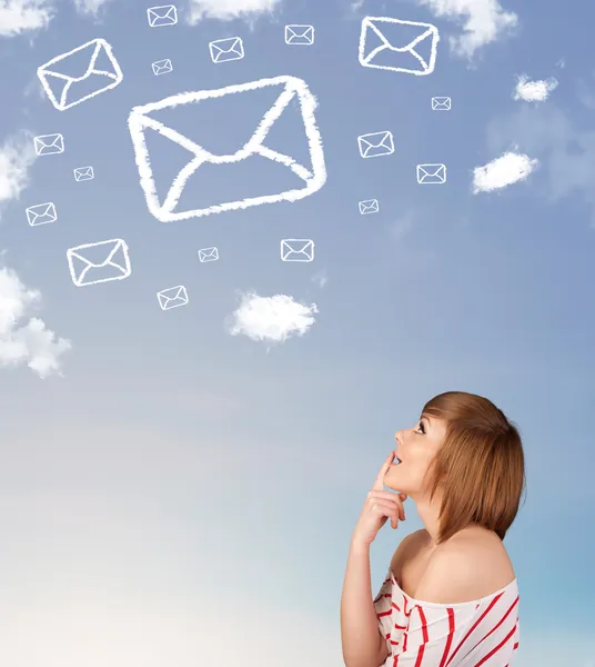 Young girl looking at mail symbol clouds on blue sky — Stock Photo, Image