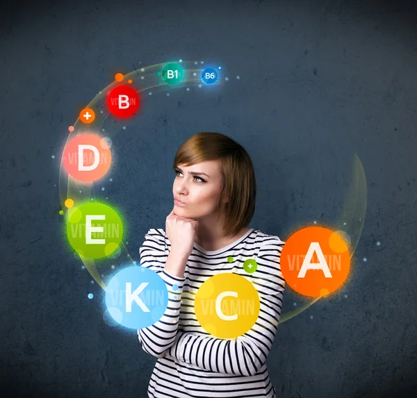 Young woman thinking with vitamins circulation around her head — Stock Photo, Image