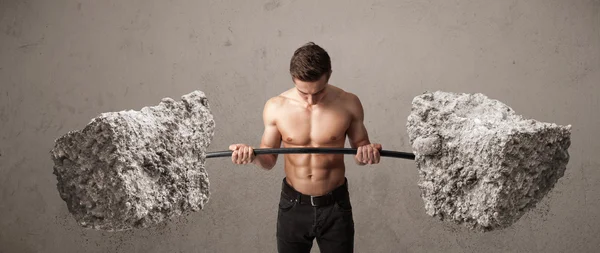 Hombre muscular levantando grandes pesos de piedra de roca — Foto de Stock