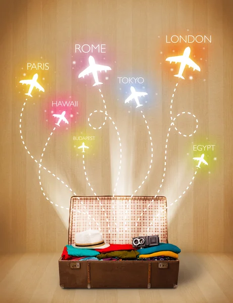 Travel bag with clothes and colorful planes flying out — Stock Photo, Image