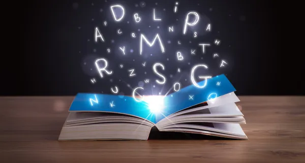 Otwarta książka ze świecącymi literami wylatującymi — Zdjęcie stockowe