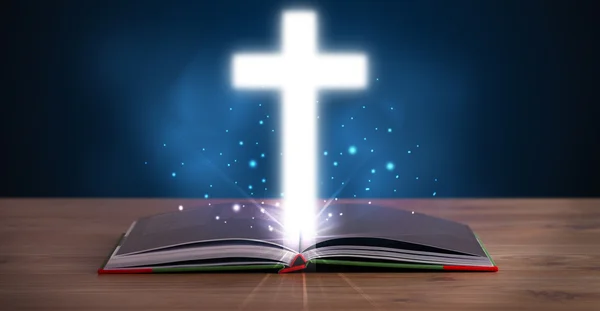 Öppen helig bibel med glödande kors i mitten — Stockfoto