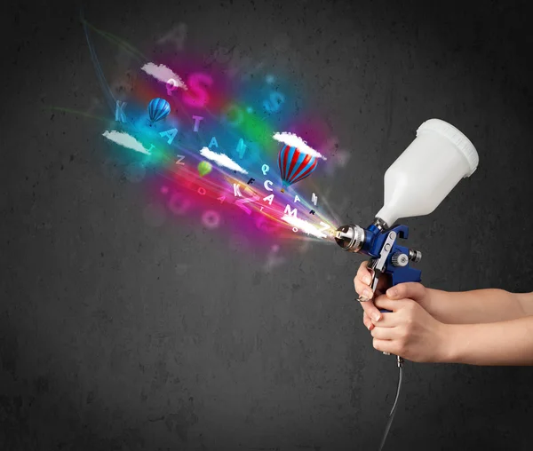 Arbeiter mit Airbrush und bunten abstrakten Wolken und Luftballons — Stockfoto