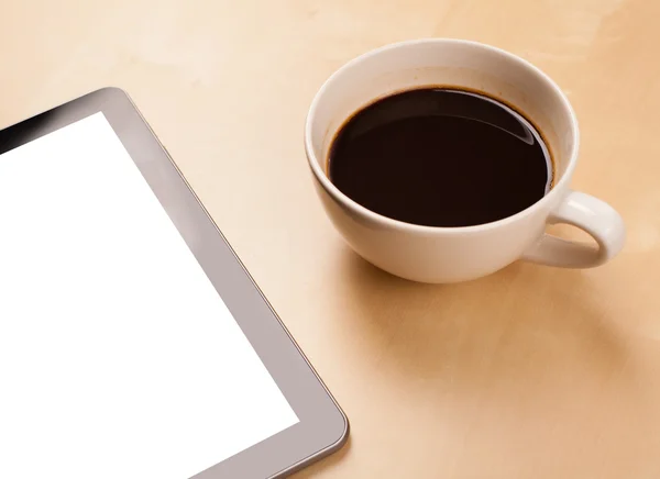 Tablet pc com espaço vazio e uma xícara de café em uma mesa — Fotografia de Stock