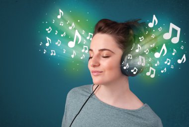 Kulaklıklı genç bir kadın müzik dinliyor.
