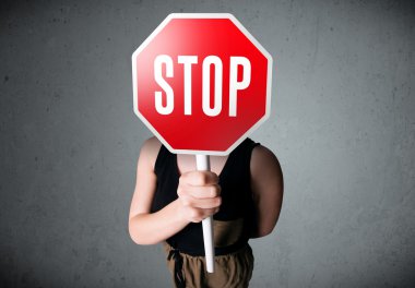 Elinde dur tabelası tutan genç bir kadın.