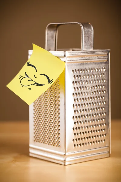 Post-it note with smiley face sticked on a grater — Stock Photo, Image