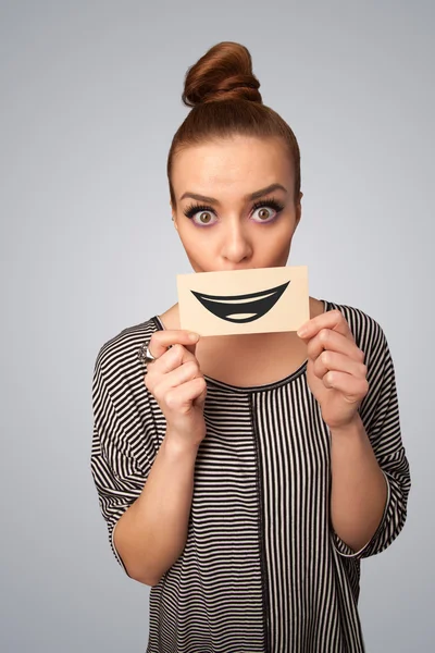 Happy pretty woman holding card with funny smiley — Stock Photo, Image