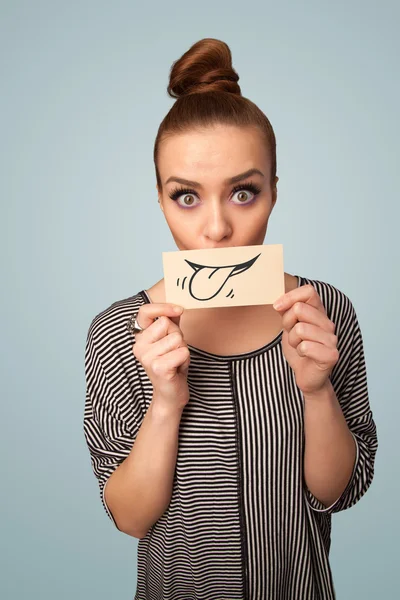 Pretty young girl holding white card with smile drawing — Stock Photo, Image